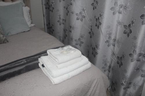 a pile of towels sitting on top of a bed at Spacious Holiday Home in Florida Park! Pool! Parking! Fast Wifi! in Roodepoort