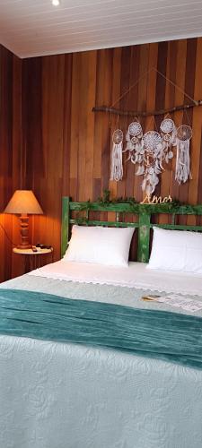 a bedroom with a bed with a wooden head board at Morada das Mandalas in Pomerode