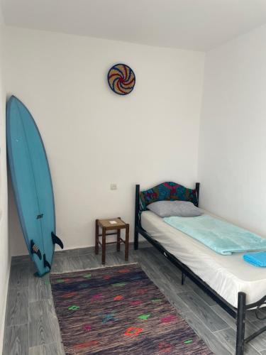 a bedroom with a bed and a surfboard on the wall at Ocean Jam Surf House in Agadir