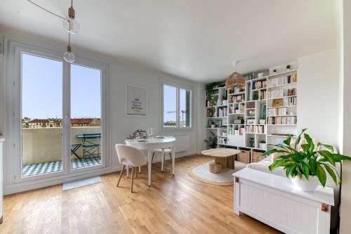 a living room with a table and a book shelf at Appartement Le perchoir - Welkeys in La Guillotière