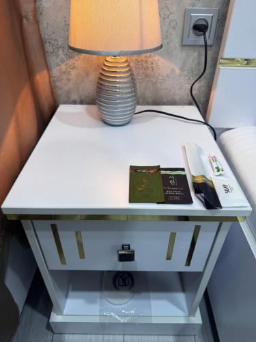 a table with a lamp and books on it at Salomat guest house in Samarkand