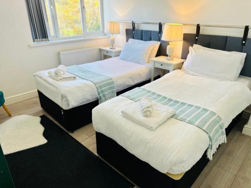 a hotel room with two beds with towels on them at Modern & Cosy 2-Bed Apartment Near NEC, Airport & JLR! in Birmingham