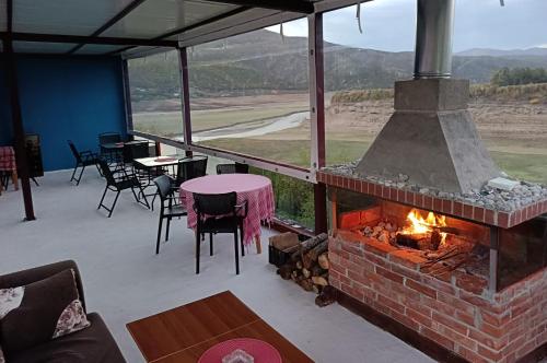 un patio con chimenea de ladrillo, mesas y sillas en SuperPanorama GuestHouse, en Kukës