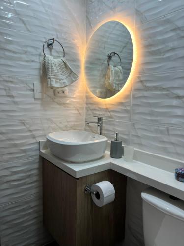 a white bathroom with a sink and a mirror at Apartamento Moderno 2 HAB Cerca U del norte in Barranquilla
