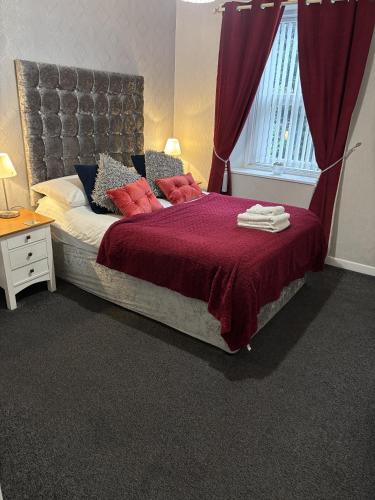 a bedroom with a large bed with red pillows at The Georgian Guesthouse in Alnwick