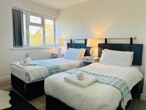 a bedroom with two beds with towels on them at Modern & Cosy 2-Bed Apartment Near NEC, Airport & JLR! in Birmingham