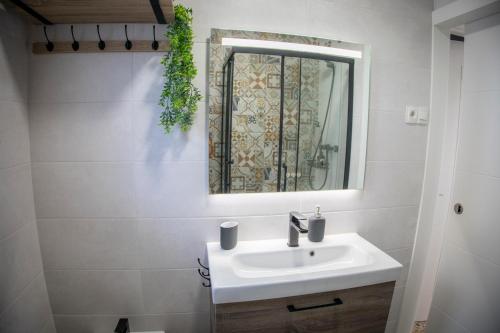 a bathroom with a sink and a mirror at Babel 11 Centro in Vélez de Benaudalla