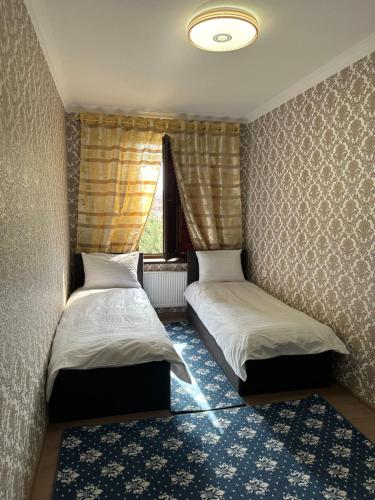 Dos camas en una habitación con ventana. en GoHostel, en Samarkand