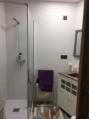 a bathroom with a shower with a purple towel on a chair at Losfresno beach in Puebla de Farnals