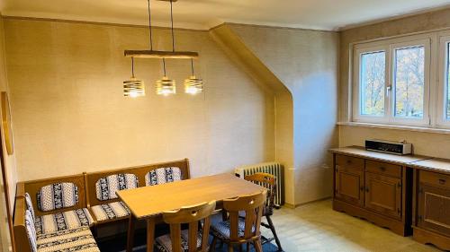 Un comedor con mesa y sillas de madera. en Becci Apartment-Free Parking, en Kapfenberg