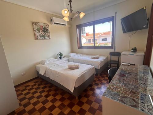 a hotel room with two beds and a window at Maia Oporto Suites in Maia