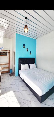 a bedroom with a large bed with a blue wall at Depik Inn in Takengon