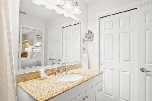 a white bathroom with a sink and a mirror at Anna Cabana Bungalow #3 in Holmes Beach