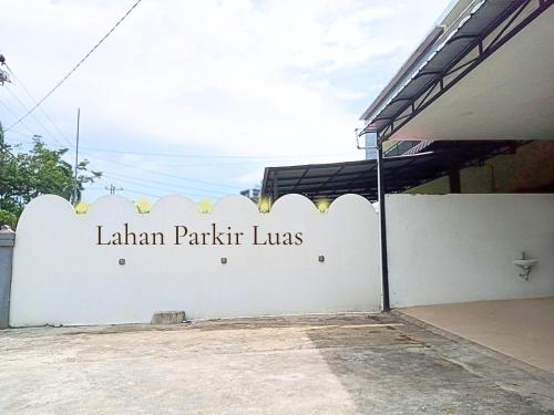 a white wall with a sign that reads lilian parkark laws at Home Suite Home Singkawang in Singkawang