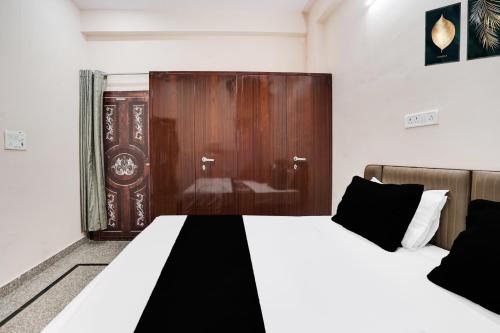 a bedroom with two beds and a wooden door at Hotel O Starlight Stay Jaipur International Airport in Jaipur