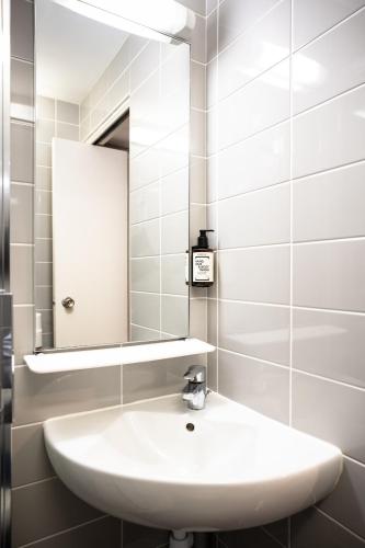 a bathroom with a white sink and a mirror at Tulip Inn Beaune in Beaune