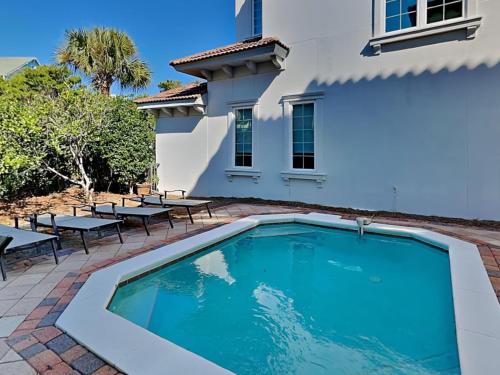 a swimming pool in front of a house with tables and chairs at Blue Mountain Bella in Blue Mountain Beach