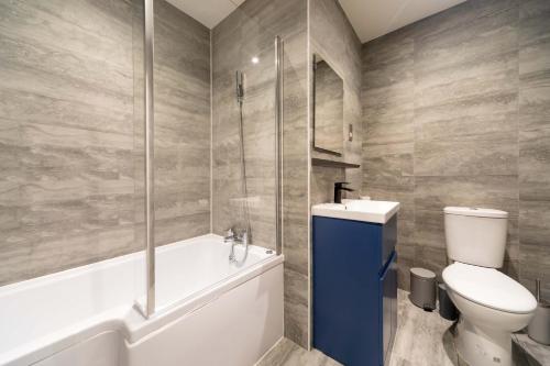 a bathroom with a toilet and a tub and a sink at Modern 1 Bedroom Apartment in Brockley, SE London in London