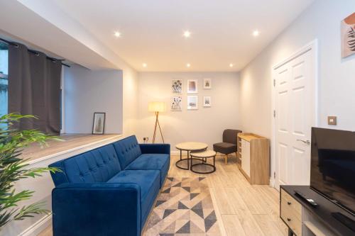a living room with a blue couch and a table at Modern 1 Bedroom Apartment in Brockley, SE London in London