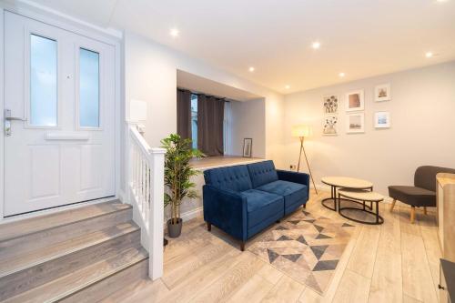 a living room with a blue couch and a table at Modern 1 Bedroom Apartment in Brockley, SE London in London