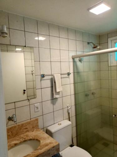 a bathroom with a toilet and a glass shower at Golden Dolphin Taperapuan Apt 529 in Porto Seguro