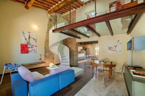 a living room with a blue couch and a staircase at Chianti B&B Design infinity pool shared in Pianella