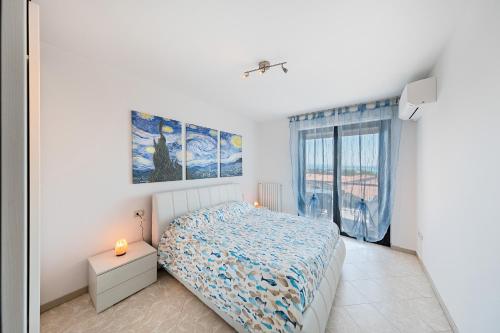 a white bedroom with a bed and a window at Garda Si Lake View With Pool in Desenzano del Garda