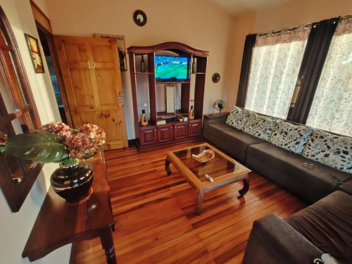 Una sala de estar con un sofá y una mesa de café. en Mi Casa Su Casa Monteverde, en Monteverde