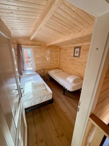 a small room with two beds in a cabin at Le Chalet de la Vernie in Saint-Léger-les-Mélèzes