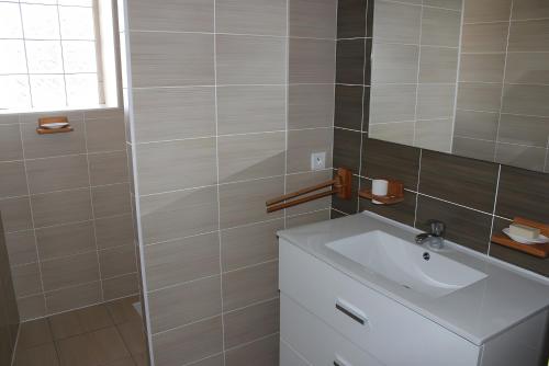 ein Badezimmer mit Waschbecken und Spiegel in der Unterkunft Résidence Brise de Mer - 1 in Port Nayalo