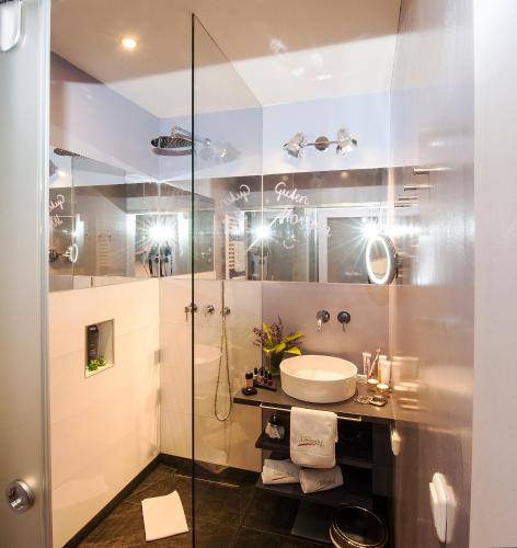 a bathroom with a sink and a shower at Hotel LÄRCHENHOF in Kleinarl