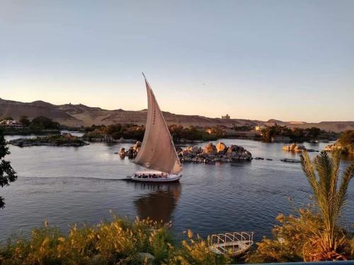 a sailboat on a river with aiety of rocks at Shipa's nubian house in Aswan
