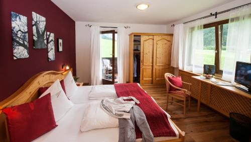 a bedroom with a bed with a red wall at Hotel LÄRCHENHOF in Kleinarl