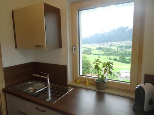 eine Küche mit einem Waschbecken und ein Fenster mit Aussicht in der Unterkunft Panorama Apartment in Bruck am Ziller