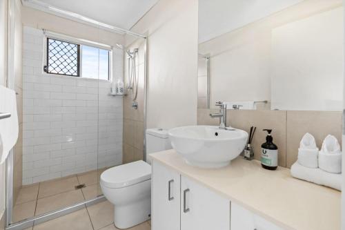 a white bathroom with a toilet and a sink at Cozy 2BR Home Quiet Bellbird Park Stay in Bellbird Park