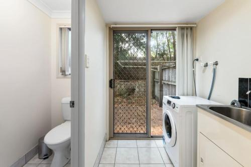 ein Badezimmer mit Toilette, Waschbecken und Waschmaschine in der Unterkunft 3BR Townhouse Stylish Living in Sunnybank Hills in Brisbane