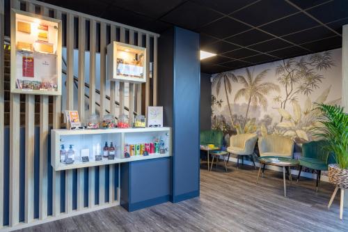 Habitación con paredes azules, mesas y sillas. en Hôtel AKENA Nantes Orvault - Ouest, en Orvault