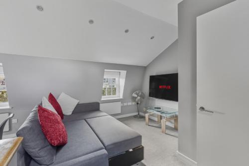 a living room with a couch and a flat screen tv at Stylish 2BR Retreat Steps from Kings Cross in London