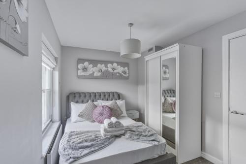 a bedroom with a bed with two towels on it at Stylish 2BR Retreat Steps from Kings Cross in London