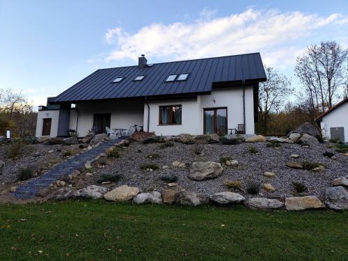une maison avec un toit noir au sommet d'un tas de rochers dans l'établissement Somewhere Between Apartments, à Piechowice