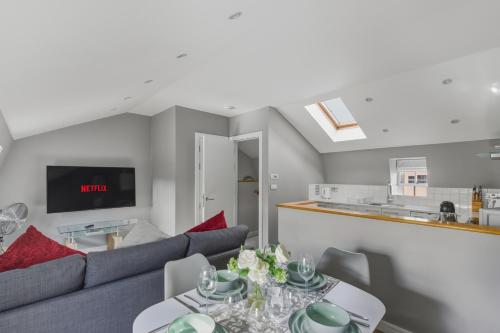 a living room with a couch and a table at Stylish 2BR Retreat Steps from Kings Cross in London