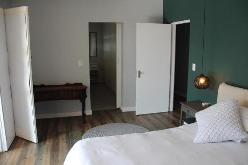een slaapkamer met een bed, een tafel en een piano bij Goodholme Guesthouse - Modern Spacious Peaceful in Durban