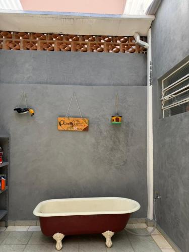 a bathroom with a tub and a sign on the wall at Pousada Lua Nova in Sorocaba