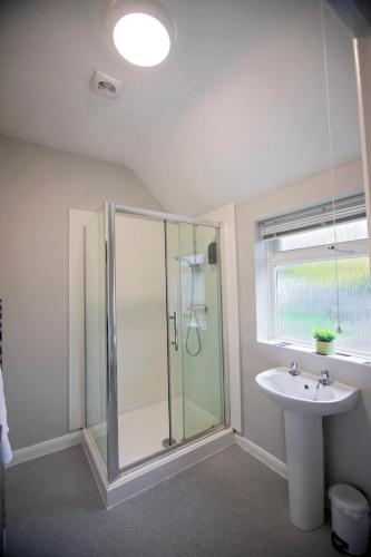 a bathroom with a glass shower and a sink at Stanmore House - Winchester in Pitt