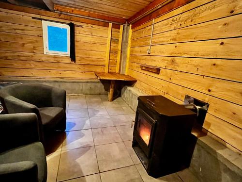 una habitación con estufa de leña en una cabaña en Cabane 2, en Olivese