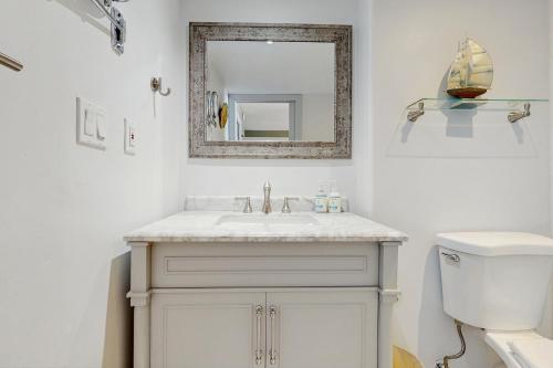 a white bathroom with a sink and a mirror at Hale Ono Loa 406 in Honokowai