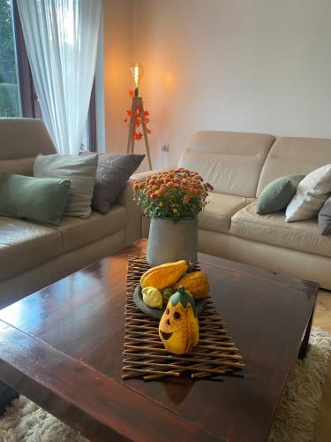 ein Wohnzimmer mit einem Couchtisch mit einer Vase in der Unterkunft Erelia Cottage in Bük