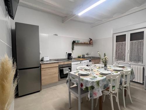 a kitchen with a table with chairs and a refrigerator at Casa rural Entre Dos Rios in Murillo de Río Leza