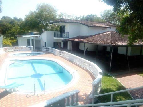 a large swimming pool in front of a house at Finca Campestre Foundation Ecopiensa Evolution in Andalucía