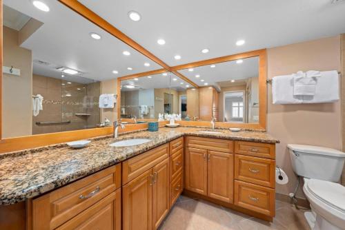 a bathroom with a sink and a toilet and a mirror at Kings Crown 309 in Sanibel